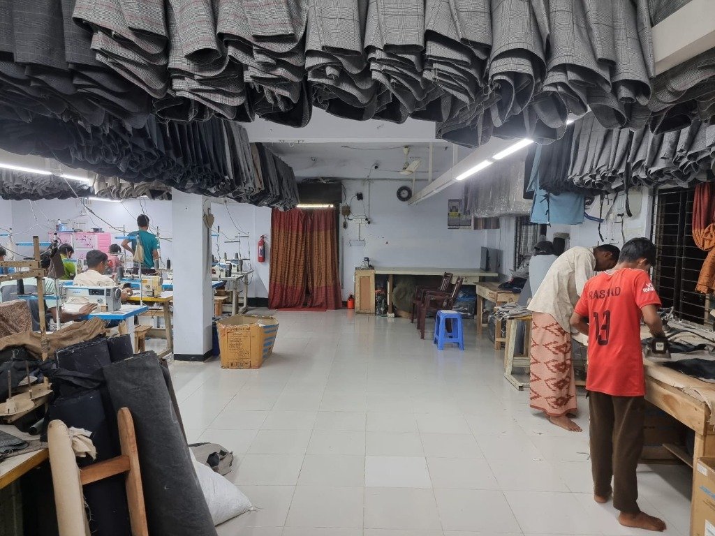 Workers at sewing stations — rear view of production floor
